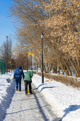 Moscow, Russia - March 20, 2023: janitor cleans snow in the park