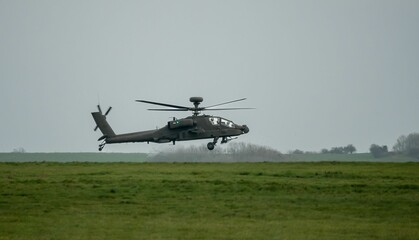 Military helicopter landing in a field