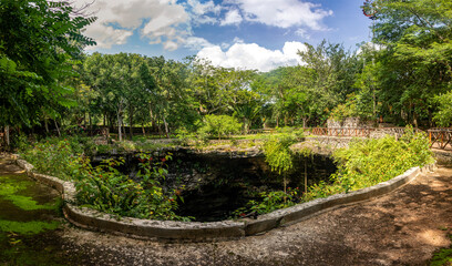 Panoramic view of the mouth of the subway cenote Saamal of chichén itzá is in the Mayan jungle hacienda of the Yucatan Peninsula in Mexico, this is an ideal place for tourists and summer vacations. - obrazy, fototapety, plakaty