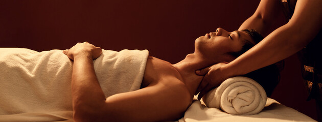 Relaxation Asian man customer get service aromatherapy massage neck and shoulder with masseuse in spa salon.