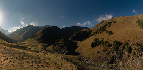 A panoramic shot of the vast mountain valley of the Turkestan Mountains in Kyrgyzstan.