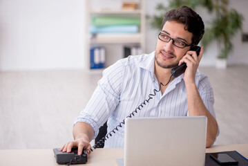 Fototapeta premium Young male employee working in the office