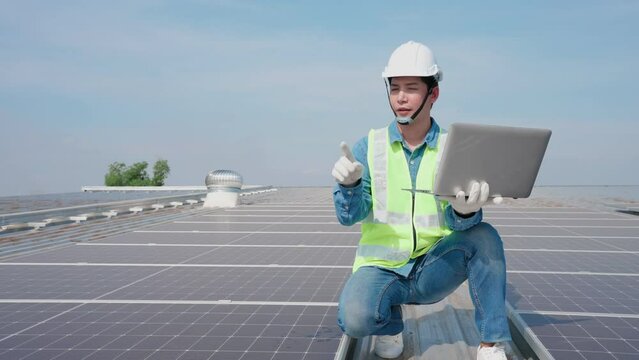 Engineer Asian man counting amount panel of solar and record data in laptop on roof top at factory, Final check or Annual Maintenance concept