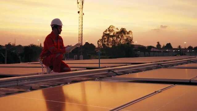 Engineer Asian man counting amount panel of solar and record data in tablet on roof top at factory, Final check or Annual Maintenance concept