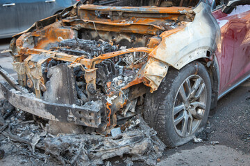 Fototapeta na wymiar Abandoned burnt-out car after the explosion, ready for scrapping. The burnt-out interior of the car, a close-up of the fire, extinguishing the fire. A burnt-out car, due to a short circuit, arson. 