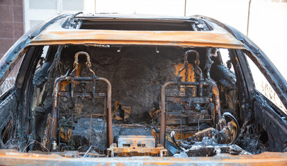 Abandoned burnt-out car after the explosion, ready for scrapping. The burnt-out interior of the...