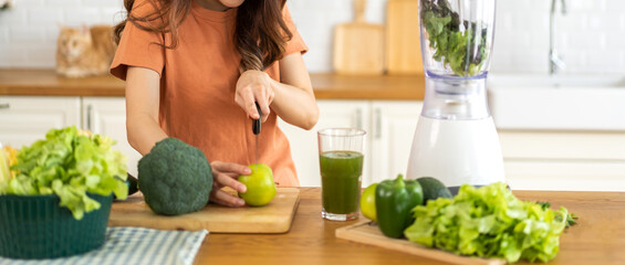 Obraz na płótnie Canvas Portrait of beauty healthy asian woman making green vegetables detox cleanse and green fruit smoothie with blender.young girl drinking glass of green fruit smoothie in kitchen.Diet concept.healthy
