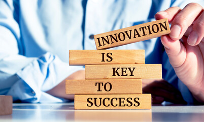 Close up on businessman holding a wooden block with "Innovation is key to success" message