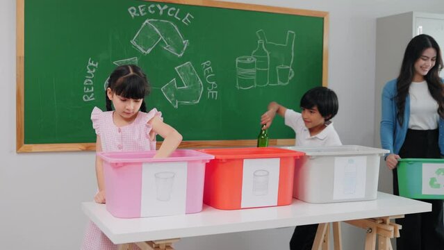 Teacher woman is teaching a class on selecting and separating waste for recycling, Student with recycle trash in classroom at elementary school