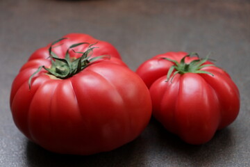 Red tomatoes  oxheart variety  a brown background