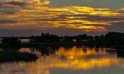 Beautiful sunset over the swamp in Louisiana, the reflection of clouds in the water, USA