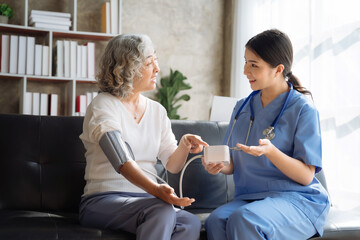 Female doctor having blood pressure test elderly woman at the clinic in the morning.