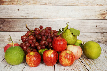 Various of fruits with Red grape, red apple and green orange on wooden background