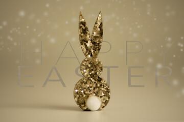 Golden glitter rabbit, background gold with lettering in the background happy easter, bokeh in blurred
