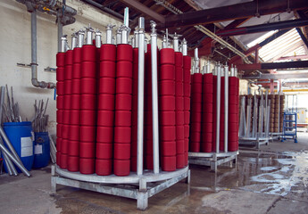 Red spindles of industrial cotton in a weaving factory, machine weaving cotton for the fashion and...