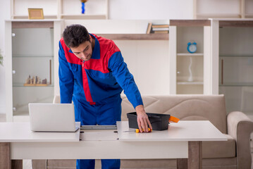 Young male carpenter working at home