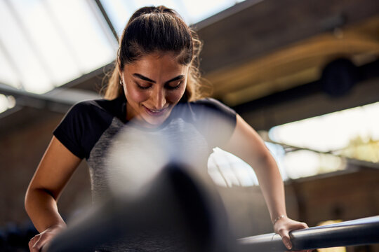 Smiling woman working out on parallel bars
