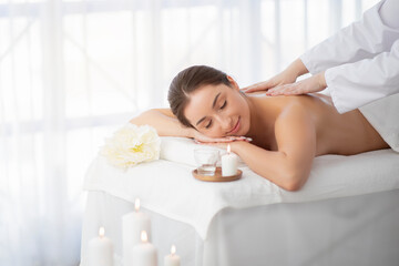 Beautiful young indian woman having full body massage at spa salon