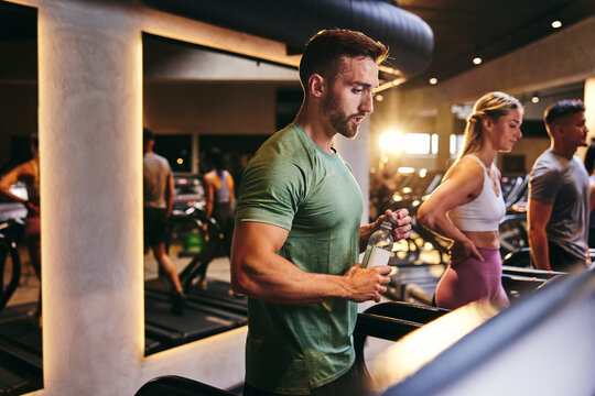 Fit man drinking after a gym workout