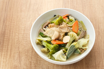 Capcay, stir fried vegetables with shrimp, meatballs and chicken. Served in white plate
