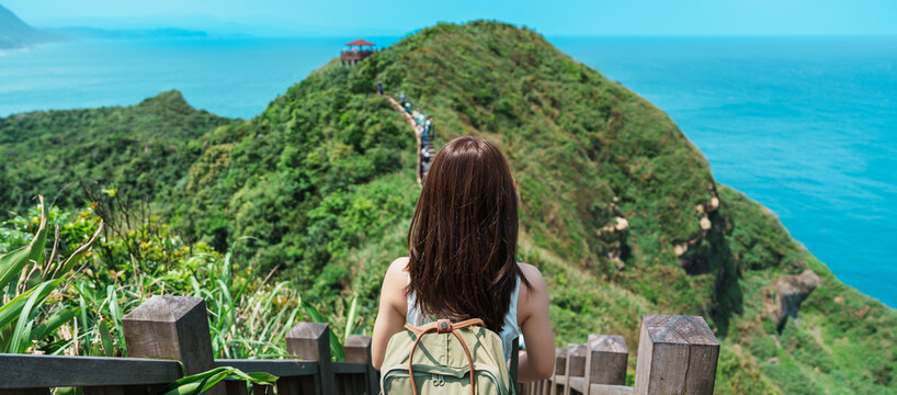 woman traveler visiting in Taiwan, Tourist with backpack sightseeing in Bitou Cape Hiking Trail, New Taipei City. landmark and popular attractions near Taipei. Asia Travel concept