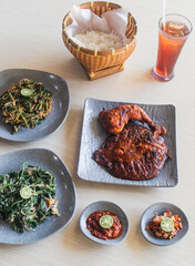 Indonesian food of Lalapan ayam, lalapan mujaer and sayur plecing with rice bowl