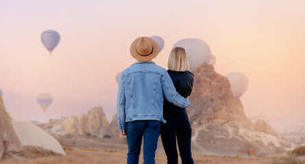 Romantic honeymoon in Cappadocia Turkey. Loving couple hugging against background of hot air...