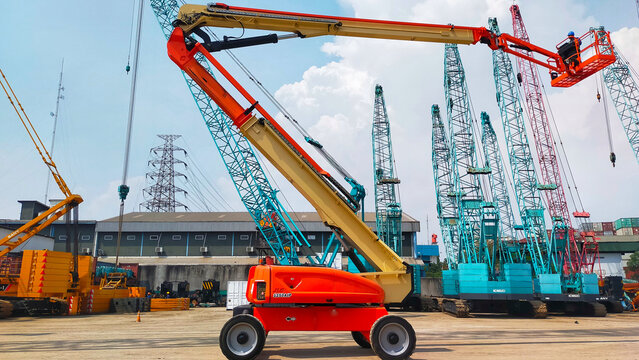 Jakarta, Indonesia - June 22, 2022: Boom lift 38 meter JLG 1250 AJP articulate type working on boom up at the yard.