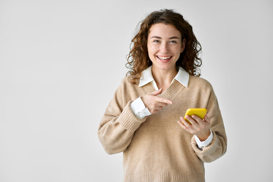 Young Happy Pretty Woman Model Pointing At Phone Isolated On White. Smiling Girl User Holding Cellphone Using Cell Presenting New App, Advertising Mobile Web Services, Recommending Shopping Promotion.