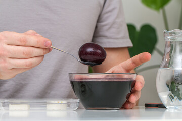 A man takes out colored Easter eggs from colored water.