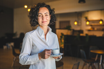 Mature woman having cup of coffee at home or office in morning