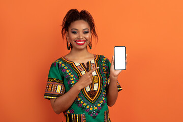 Cheerful pretty black woman holding phone with mockup