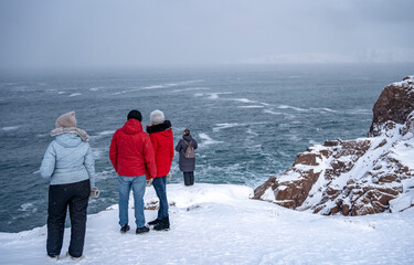 Tourists on the shores of the Barents Sea. Teriberka. Russia March 2023