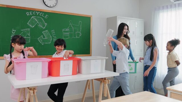 Teacher woman is teaching a class on selecting and separating waste for recycling, Student with recycle trash in classroom at elementary school