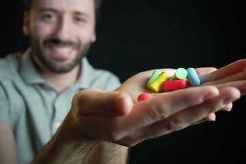 Man holding many silicone ear plugs in his hands 