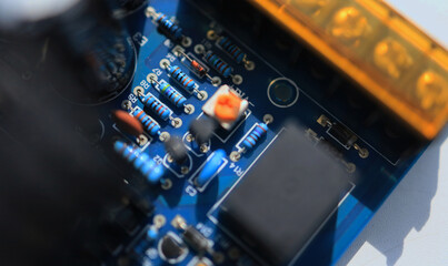 Fototapeta na wymiar A macro shot of a resistor as a component of an blue electronic circuit.
