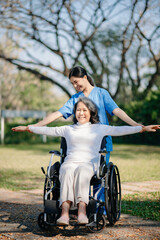 Obraz premium Asian young caregiver nurse support senior older male walking outdoors. Specialis doctor help and take care of elderly mature.