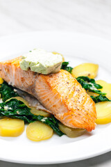 baked salmon with spinach leaves and potatoes