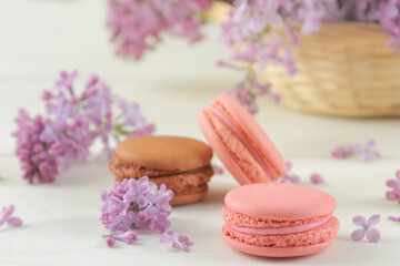 Fototapeta na wymiar Macaron cake and a bouquet of lilacs on a light background