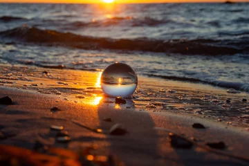 Papier Peint photo Lavable Réflexion Beach and sea reflected in a sphere lying in the sand in the waves