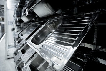 Angle view of rows metal kitchen sink at the showroom of a large store.