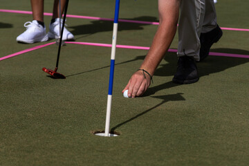 Golf instructor teaches how to place the ball on the grass