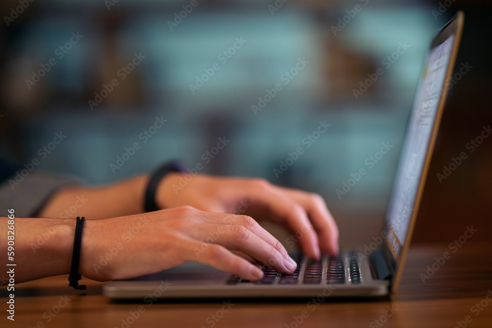 Poster Cropped of man touching laptop computer keyboard, blurred background