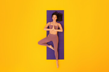 Top View Of Lady Doing Yoga Lying Over Yellow Background