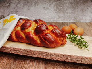 braided cake with eggs on wooden tray
