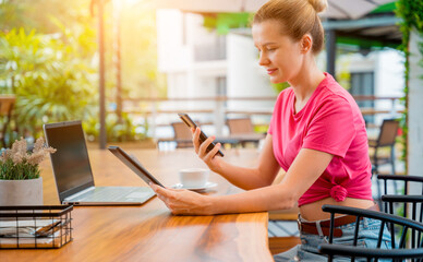 Woman using contactless payment by mobile phone with QR code at cafe