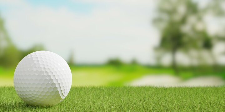 Golf ball close up on green grass or lawn with golf course fairway blurred background, golf sports or activity concept with copy space