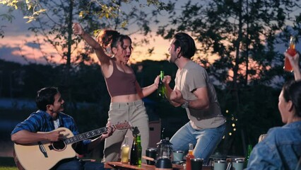 Happy young friends traveler group having fun music and dancing together in camping party, Group of multiculturalism hipster people enjoying holiday vacation trip in campsite