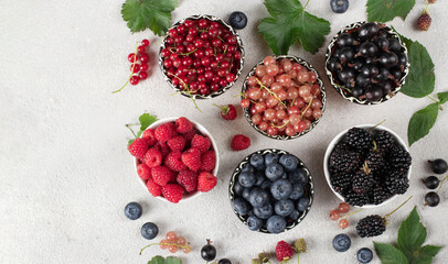 Summer vitamin food concept, set of various berries - blueberry, raspberry, blackberry, red white and black currant in bowls on gray table, Top view