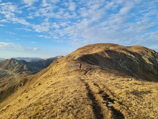 Distant view of a male hiker on the mountain at sunrise in Dolomites, Italy